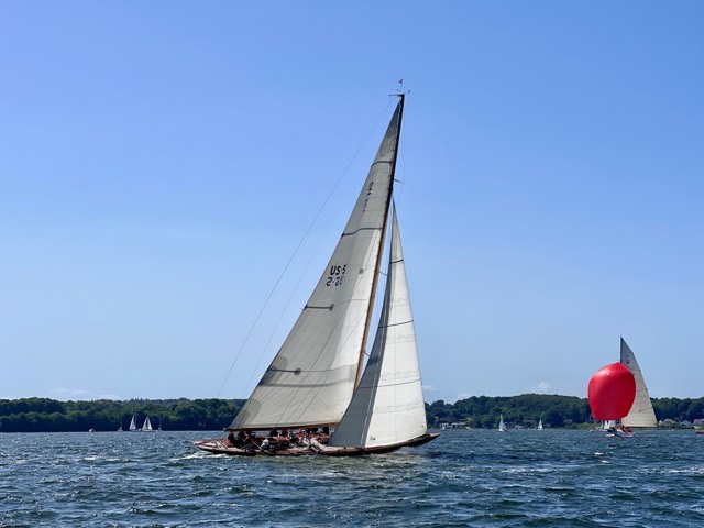12mR-Yacht „US 2“ mit rotem Spinnaker im Hintergrund