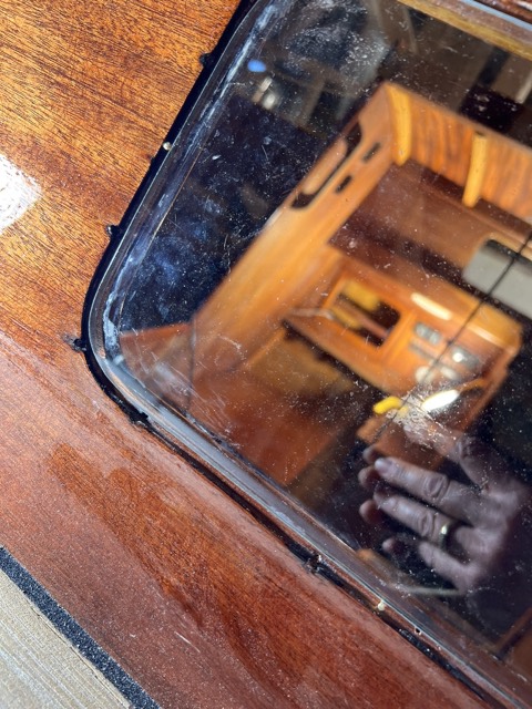 Die eingepasste Scheibe sitzt in der Fensteröffnung, im Glas spiegelt sich der Salon