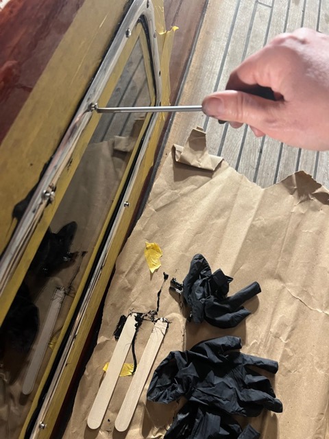 Verschrauben des Rahmens, daneben verbrauchte Handschuhe und Holzspatel auf Packpapier
