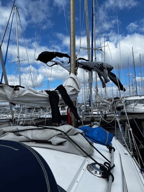 Zum Trocknen aufgehängte Kleidung am Mast im Hafen