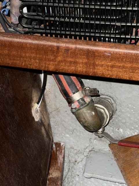 Alter, korrodierter Borddurchlass mit Schlauch